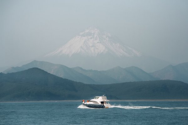 boat on the water with a mountain in the background 